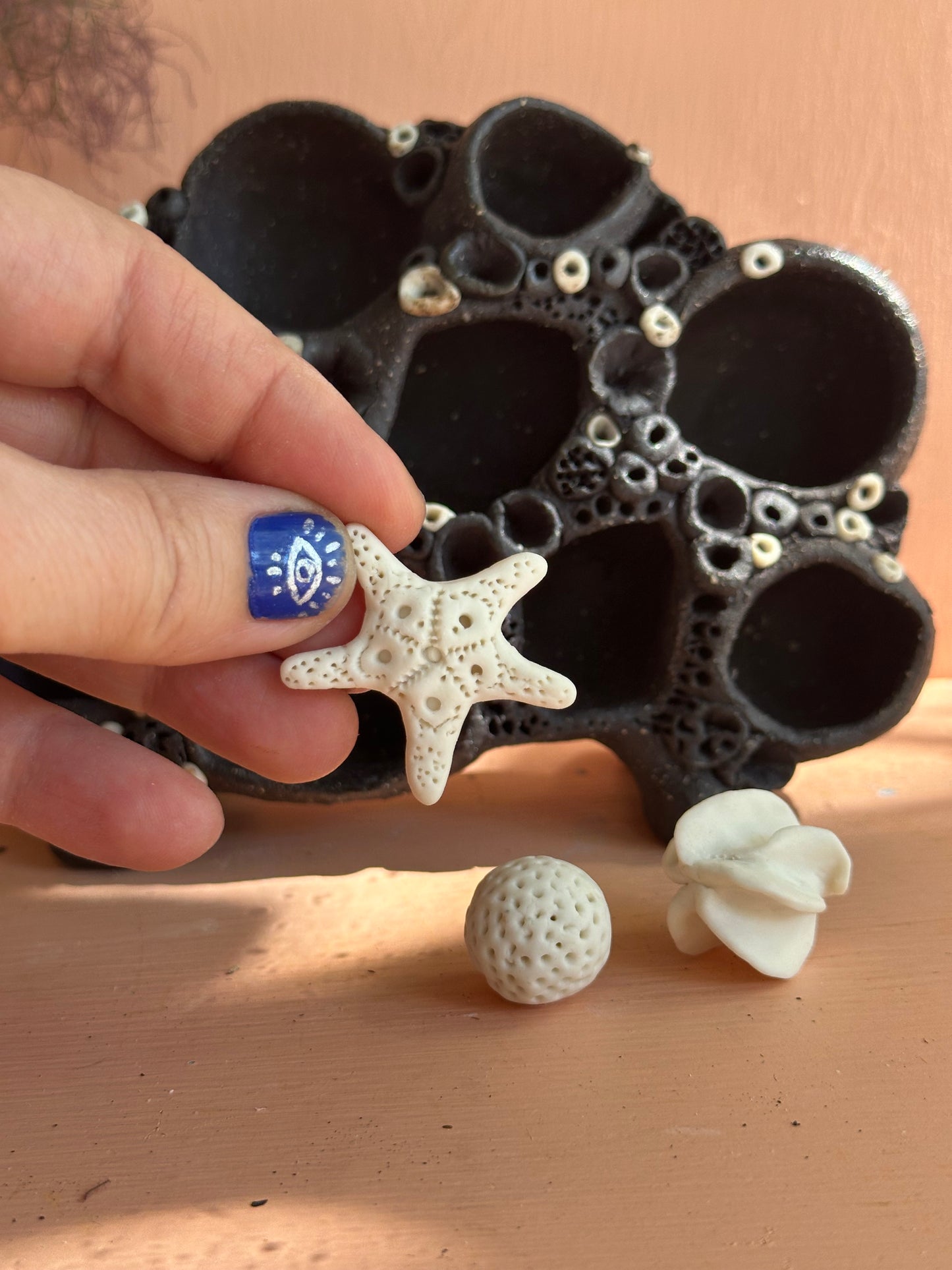 Dark clay ‘treasure shelf’ with 3 porcelain accessories